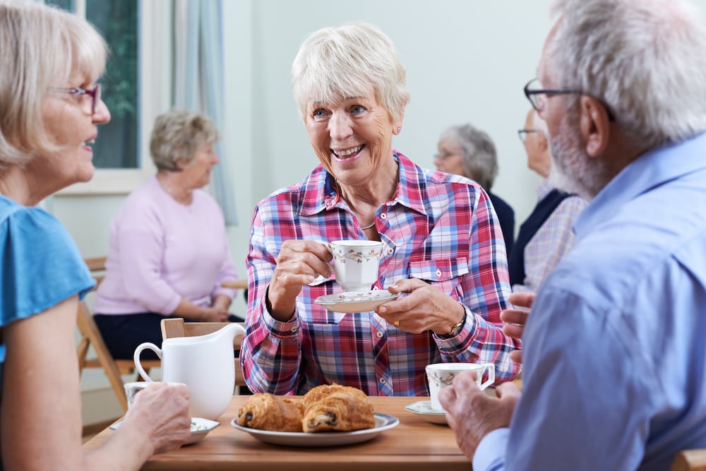 Eine Gruppe älterer Freunde genießt zusammen Kaffee